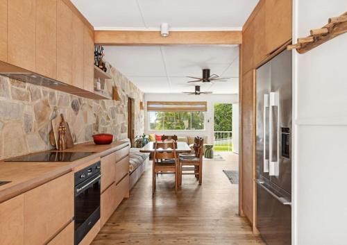 a kitchen with a table and a dining room at Sundowner Suite No. 2 in Yamba