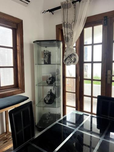 a glass table and chairs in a room with windows at Mami & Me Villa in Kendwa