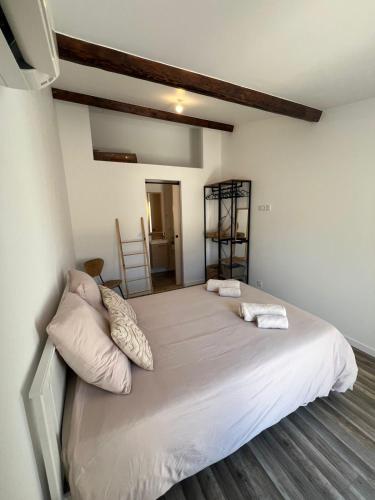 une chambre avec un grand lit avec des draps et des oreillers blancs dans l'établissement Maison localisation idéale proche gare Saint Charles - Friche Belle de Mai et centre ville, à Marseille