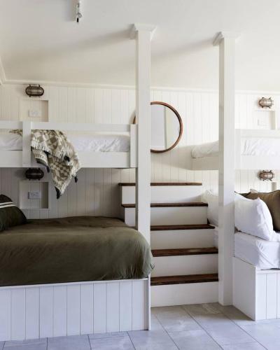a bedroom with two bunk beds and a staircase at The Black Ace Yamba in Yamba