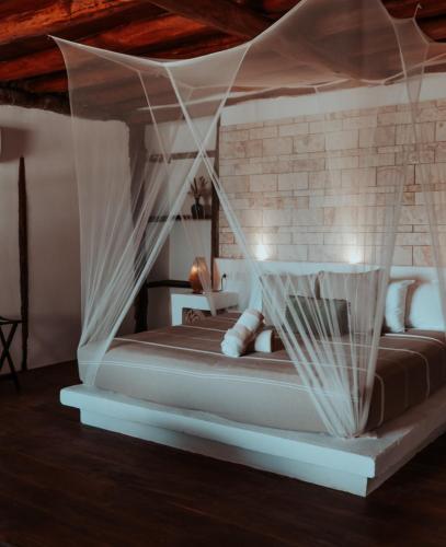a bedroom with a bed with mosquito netting at Niken Beachfront Tulum Hotel in Tulum