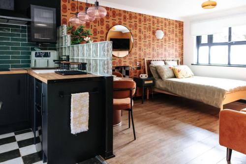 a kitchen and a living room with a bed in a room at 70s Hideaway Guest Studio for 2 I Private I Self Contained I Near Cardiff in Cardiff