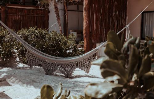 a hammock in a room with plants at Niken Beachfront Tulum Hotel in Tulum