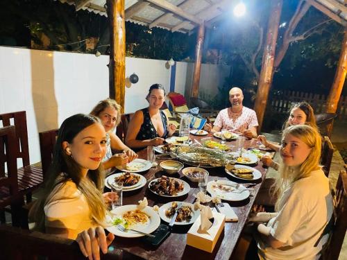 a group of people sitting at a table eating food at Lima Blue Private Beach Apartment in Trincomalee