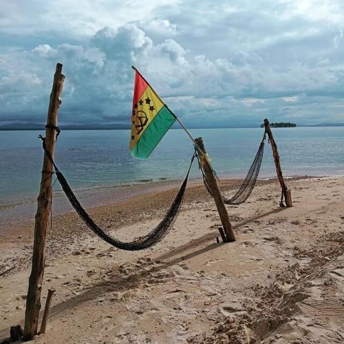 a kite is tied to wooden poles on the beach at Private Cabin on Aroma Island in Panama City