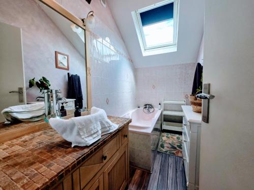 a bathroom with a sink and a bath tub and a sink at Appartement Cozy - Dernier Étage - Parking Auxerre in Auxerre
