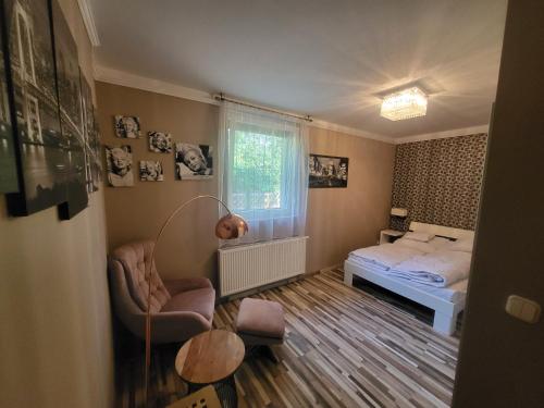 a bedroom with a bed and a table and a chair at G&G Apartman in Balatonszepezd