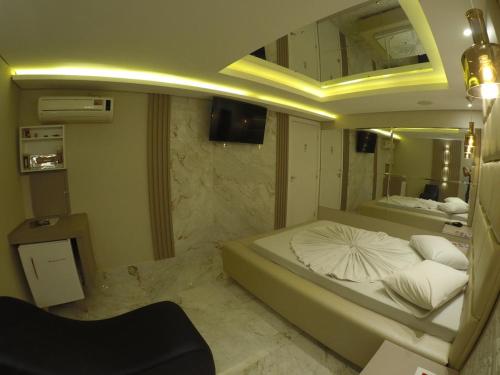 a bedroom with two beds and a mirror at Motel Tenda in Maringá
