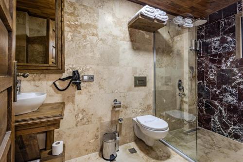 a bathroom with a toilet and a glass shower at Soho Cappadocia in Goreme