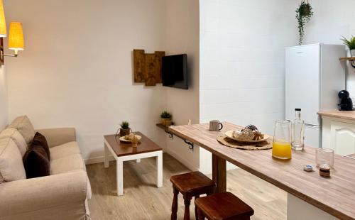 a living room with a table and a couch at Canaryislandshost l Olympica in Teguise