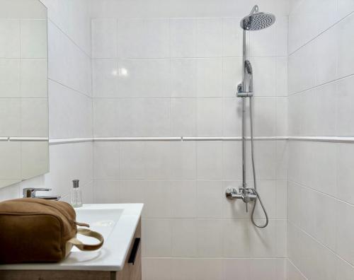 a white bathroom with a shower and a sink at Canaryislandshost l Olympica in Teguise
