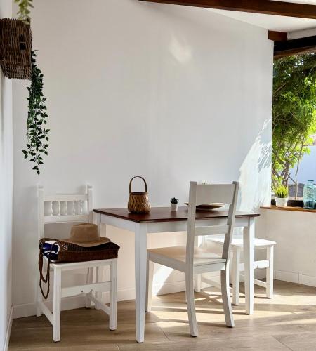 a white table and chairs with a table and a bench at Canaryislandshost l Olympica in Teguise