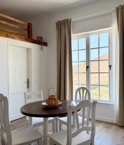 a dining room with a table and chairs and a window at Canaryislandshost l Olympica in Teguise