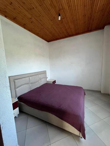 a bedroom with a bed with a purple blanket at Guest House Novaku 