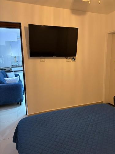 ein Wohnzimmer mit einem Flachbildfernseher an der Wand in der Unterkunft Perfect House 2 in Eilat