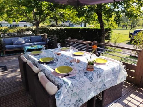une table avec des assiettes et des verres sur une terrasse dans l'établissement Fun et Nature, à Biscarrosse