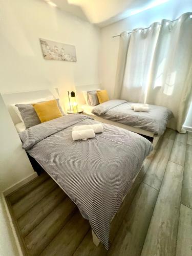 two beds sitting next to each other in a bedroom at Cosy apartment in town centre in Finedon