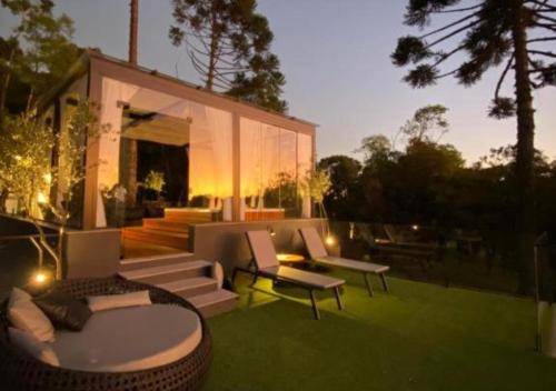 a house on a lawn with a table and chairs at Studios Heaven in Gramado