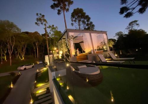 a house with a balcony with a car on the street at Studios Heaven in Gramado