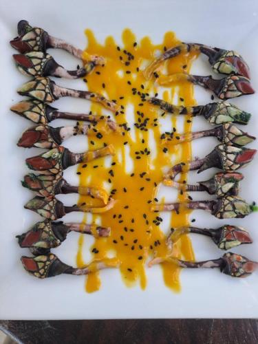 a plate of food with yellow sauce on it at H0TELIER Home, Máncora in Máncora