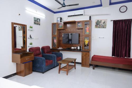 a living room with a couch a chair and a desk at Nivaa Stays - Near JIPMER in Pondicherry