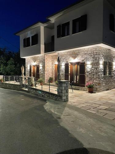 un bâtiment en briques avec des lumières devant dans l'établissement Pelion Bloom, à Zagora