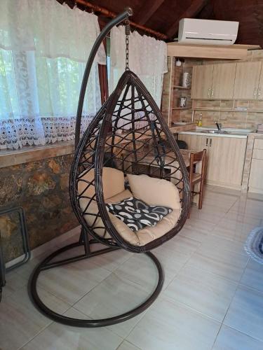 a hanging chair in a room with a kitchen at Apartment Vistanova in Vrdnik