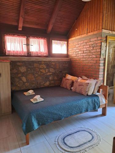 a bedroom with a bed in a brick wall at Apartment Vistanova in Vrdnik