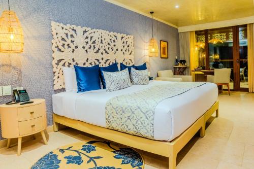 a bedroom with a large bed with blue pillows at Hotel Rio Guayas by Art Hotels in Guayaquil