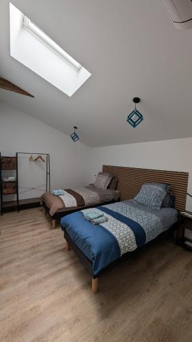 three beds in a room with wooden floors at Les roches voisines "big rock" in Solutré-Pouilly