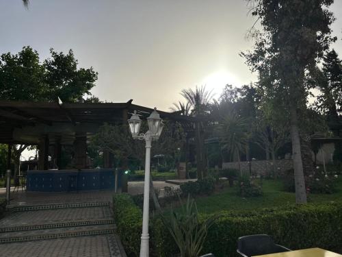 a street light in a garden with a gazebo at Zalagh Parc Palace in Fès