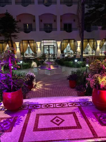 a courtyard at night with pink lighting at Zalagh Parc Palace in Fès