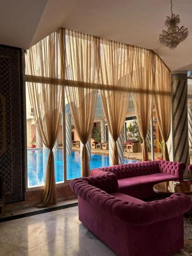 a living room with a purple couch and a large window at Zalagh Parc Palace in Fès