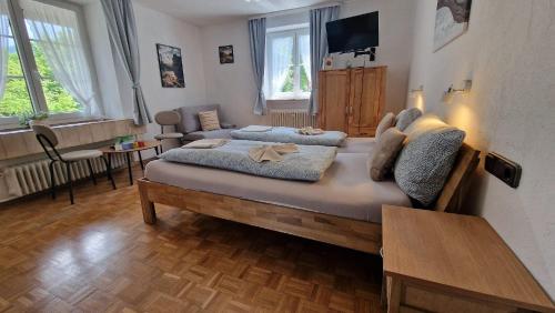 a bedroom with a large bed and a living room at Alpen Hotel Martin in Nesselwang