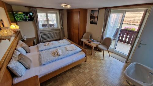 a bedroom with a bed and a bathroom with a sink at Alpen Hotel Martin in Nesselwang