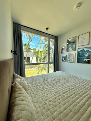 a bedroom with a bed and a large window at Bad Seerose mit Seeblick, Dachterrasse, Pool und Sauna in Bad Saarow