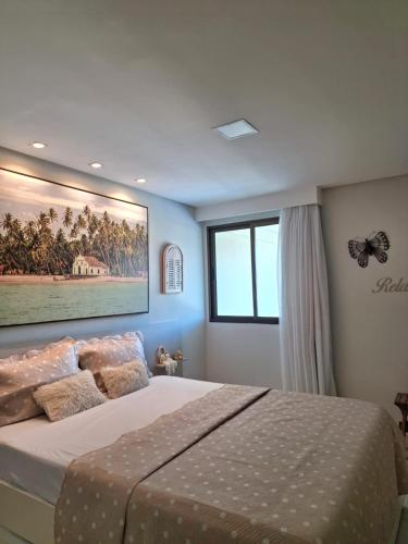 a bedroom with a bed with a picture on the wall at CARNEIROS BEACH RESORT AP 311 E in Praia dos Carneiros