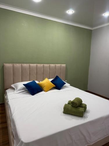 a large bed with three pillows on it at Tkacheva 14 in Pavlodar