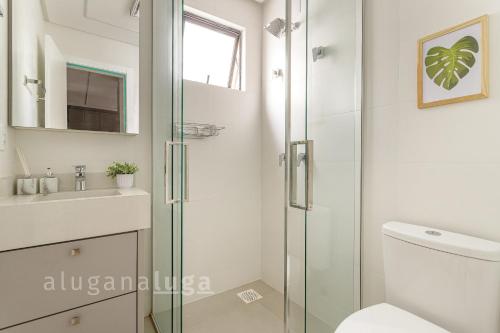 a bathroom with a shower and a toilet and a sink at Aconchego e Lazer no Coração de Itapema in Meia Praia