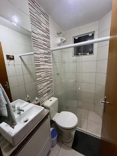 a bathroom with a shower and a toilet and a sink at Apartamento Confortável com Área Gourmet in Fazenda Rio Grande
