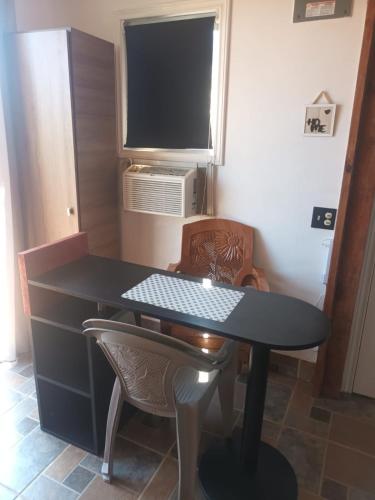 a room with a table with a television and chairs at Blue haus in Punta Caribe