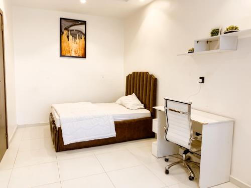 a bedroom with a bed and a desk and a computer at Ezko Apartments Lagos Business School in Lekki