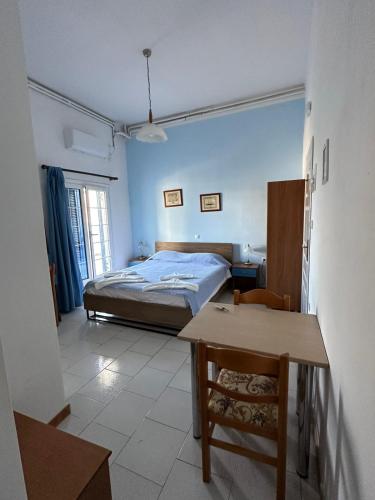 a bedroom with a bed and a table in it at Rena's Garden Rooms in Lipsoi