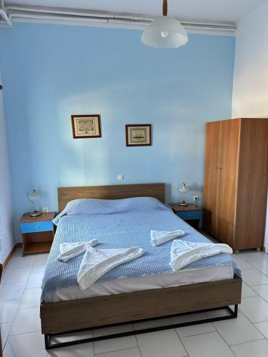 a bedroom with a bed with two towels on it at Rena's Garden Rooms in Lipsoi