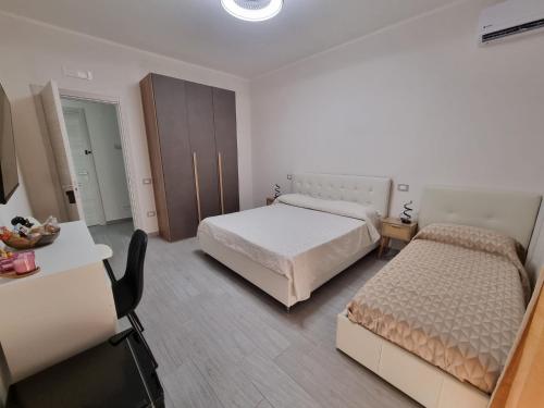 a hotel room with two beds and a desk and a room at Pagani Urban Stay in Pagani
