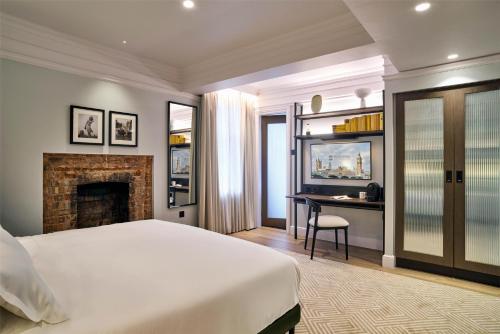 a bedroom with a bed and a desk and a fireplace at Radisson Blu Hotel, London Bloomsbury in London