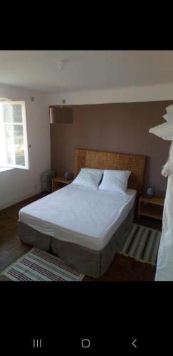 une chambre avec un lit avec des draps blancs et une fenêtre dans l'établissement Les 2 Jumeaux, à Hendaye