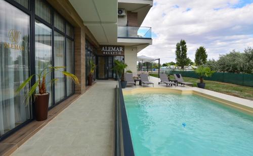 a swimming pool in front of a building at Alemar Mamaia Nord in Năvodari