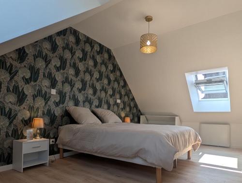 - une chambre dotée d'un lit avec un mur à motifs dans l'établissement Le Mans'ardé, au Mans