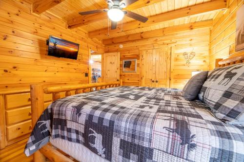 a bedroom with a bed in a log cabin at Rhythm & Blues By Avada Properties in Gatlinburg